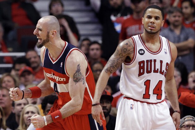 Washington Wizards center Marcin Gortat, left, reacts after scoring a basket as Chicago Bulls guard D.J. Augustin reacts during the second half in Game 1 of an opening-round NBA basketball playoff series in Chicago, Sunday, April 20, 2014. The Wizards won 102-93. (AP Photo/Nam Y. Huh)