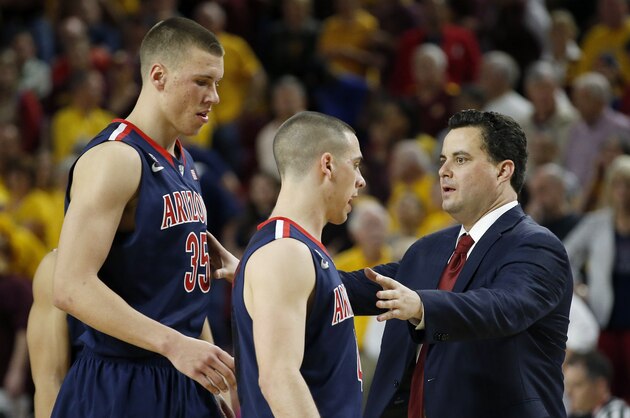 Arizona head coach Sean Miller, right, talks with his players Kaleb Tarczewski (35), and T.J. McConnell during the first overtime of an NCAA college basketball game against Arizona State, Friday, Feb. 14, 2014, in Tempe, Ariz.  Arizona State defeated Arizona 69-66 in double overtime. (AP Photo/Ross D. Franklin)