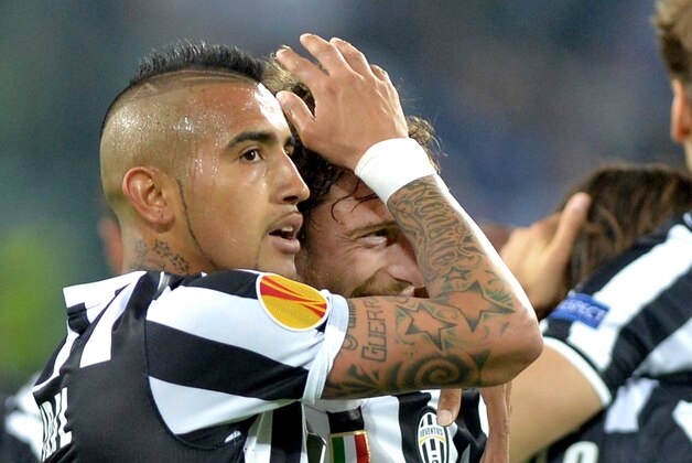 Juventus midfielder Claudio Marchisio, center, celebrates after scoring with teammate Arturo Vidal during the Europa League quarterfinal soccer match between Juventus and Olympic Lyon at the Juventus stadium, in Turin, Italy, Thursday, April 10, 2014. (AP Photo/ Massimo Pinca)