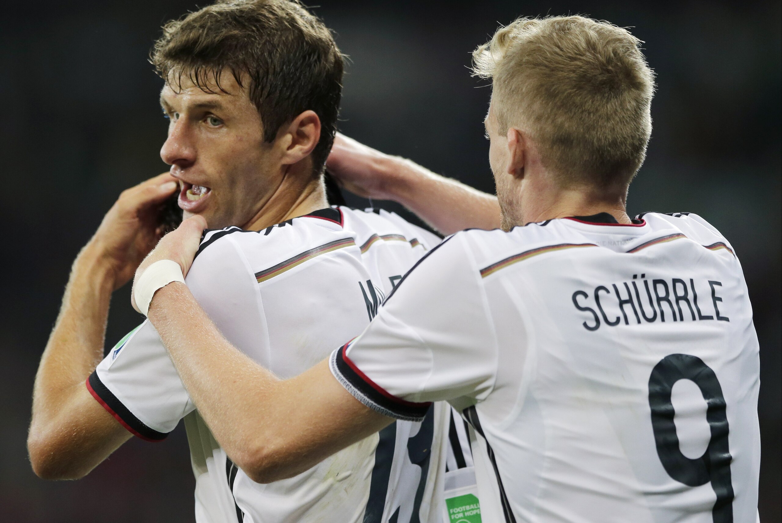 Germany's Andre Schuerrle celebrates with Thomas Mueller after Mesut Ozil scored his side's second goal in extra time during the World Cup round of 16 soccer match between Germany and Algeria at the Estadio Beira-Rio in Porto Alegre, Brazil, Monday, June 30, 2014. Germany defeated Algeria 2-1 to advance to the quarterfinals.  (AP Photo/Matthias Schrader)