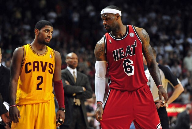 Feb 24, 2013; Miami, FL, USA; Cleveland Cavaliers point guard Kyrie Irving (left) looks over at Miami Heat small forward LeBron James (right) as Cleveland Cavaliers head coach Byron Scott (center) looks on during the second half at the American Airlines Arena.  MIami won 109-105. Mandatory Credit: Steve Mitchell-USA TODAY Sports