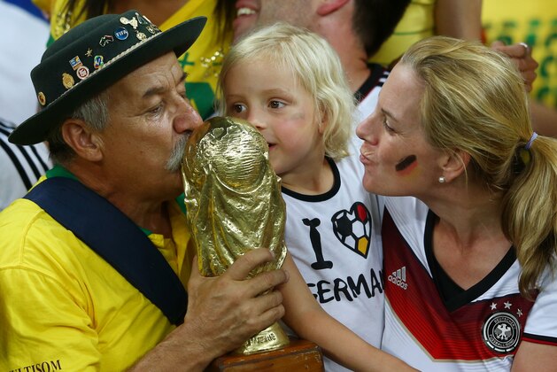 BELO HORIZONTE, BRAZIL - JULY 08: A Brazil fan and young Germany fan kiss a replica of the World Cup trophy after Germany's 7-1 win during the 2014 FIFA World Cup Brazil Semi Final match between Brazil and Germany at Estadio Mineirao on July 8, 2014 in Belo Horizonte, Brazil. (Photo by Michael Steele/Getty Images) BELO HORIZONTE, BRAZIL - JULY 08: A Brazil fan and young Germany fan kiss a replica of the World Cup trophy after Germany's 7-1 win during the 2014 FIFA World Cup Brazil Semi Final match between Brazil and Germany at Estadio Mineirao on July 8, 2014 in Belo Horizonte, Brazil. (Photo by Michael Steele/Getty Images)
