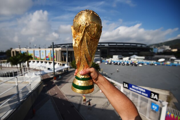 RIO DE JANEIRO, BRAZIL - JUNE 11:  A fan holds a replica of the World Cup Trophy near the Maracana Stadium on June 11, 2014 in Rio de Janeiro, Brazil.  (Photo by Matthias Hangst/Getty Images)