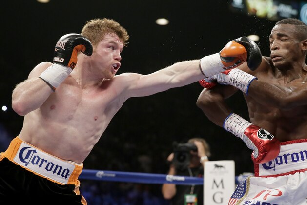 Canelo Alvarez, left, of Mexico, swings at Erislandy Lara, of Cuba, during their super welterweight fight, Saturday, July 12, 2014, in Las Vegas. (AP Photo/John Locher)