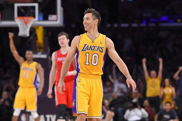 Los Angeles Lakers' Steve Nash, center, smiles after picking up an assist to take sole possession of third place for NBA all-time assists, during the first half of an NBA basketball game against the Houston Rockets, Tuesday, April 8, 2014, in Los Angeles.  (AP Photo/Mark J. Terrill)