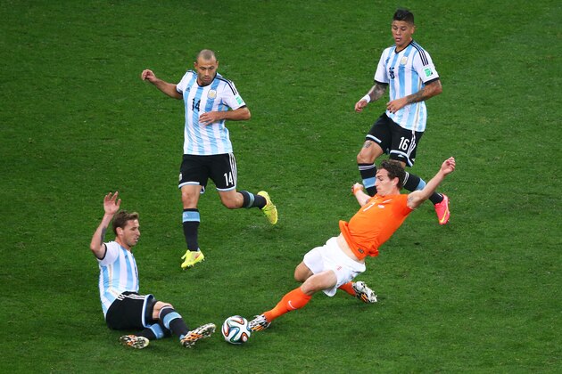 SAO PAULO, BRAZIL - JULY 09: Daryl Janmaat of the Netherlands challenges Lucas Biglia of Argentina during the 2014 FIFA World Cup Brazil Semi Final match between the Netherlands and Argentina at Arena de Sao Paulo on July 9, 2014 in Sao Paulo, Brazil.  (Photo by Julian Finney/Getty Images)