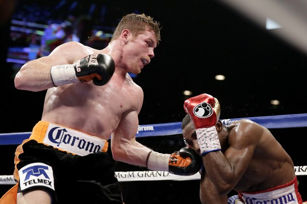 Canelo Alvarez, left, of Mexico, hits Erislandy Lara, of Cuba, during their super welterweight fight, Saturday, July 12, 2014, in Las Vegas. (AP Photo/John Locher)