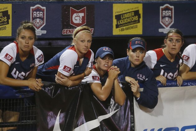 United States players watch from the dugout in the seventh inning of the World Cup of Softball tournament championship game against Japan in Oklahoma City, Sunday, July 14, 2013. Japan won 6-3. (AP Photo/Sue Ogrocki)