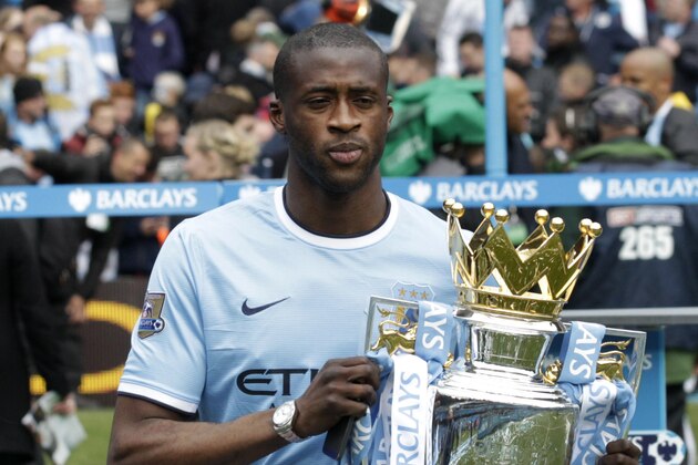 Manchester City's Yaya Toure poses for photographers with the trophy after the English Premier League soccer match between Manchester City and West Ham at the Etihad Stadium in Manchester, England, Sunday May 11, 2014.  Manchester City won the Premier League for the second time in three seasons on Sunday, completing its campaign with a comfortable 2-0 victory over West Ham that lacked any of the drama of its previous title.  (AP Photo/Jon Super)