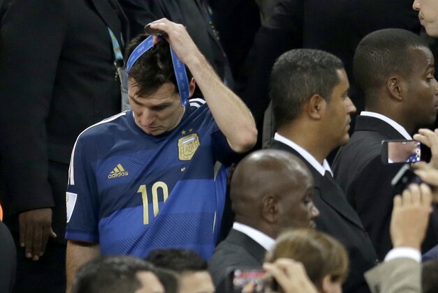 Argentina's Lionel Messi removes his silver medal after the presentation following Germany's 1-0 victory over Argentina after the World Cup final soccer match between Germany and Argentina at the Maracana Stadium in Rio de Janeiro, Brazil, Sunday, July 13, 2014. (AP Photo/Natacha Pisarenko)
