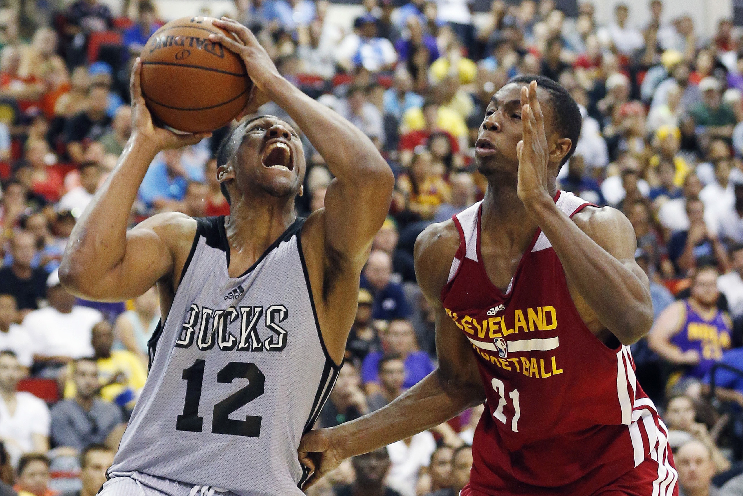 Jabari Parker (12) of the Milwaukee Bucks drives by Andrew Wiggins of the Cleveland Cavaliers in an NBA summer league basketball Friday, July 11, 2014, in Las Vegas. (AP Photo/John Locher)