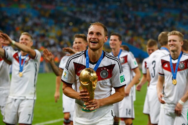RIO DE JANEIRO, BRAZIL - JULY 13:  Benedikt Hoewedes of Germany celebrates with the World Cup trophy and celebrates with teammates after defeating Argentina 1-0 in extra time during the 2014 FIFA World Cup Brazil Final match between Germany and Argentina at Maracana on July 13, 2014 in Rio de Janeiro, Brazil.  (Photo by Clive Rose/Getty Images)