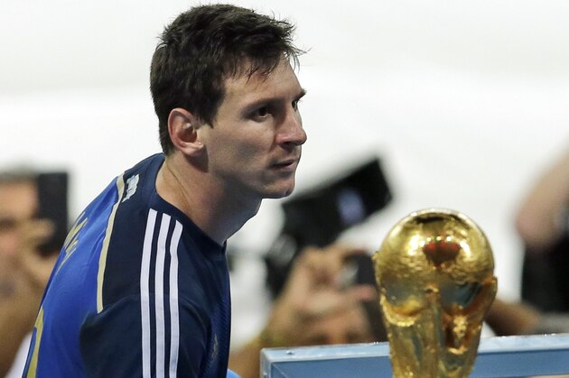 Argentina's Lionel Messi walks by the World Cup trophy as he goes on the tribune to collect the second place trophy after  the World Cup final soccer match between Germany and Argentina at the Maracana Stadium in Rio de Janeiro, Brazil, Sunday, July 13, 2014. Germany won 1-0.(AP Photo/Hassan Ammar)