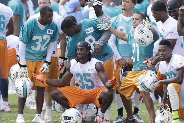 Miami Dolphins players pose for photos after a scrimmage on the final day of mini-camp, Thursday, June 19, 2014 at the Dolphins Training Facility in Davie, Fla. (AP Photo/Wilfredo Lee)