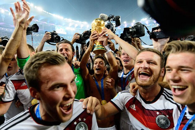 RIO DE JANEIRO, BRAZIL - JULY 13:  Mesut Oezil of Germany raises the World Cup trophy with teammates Kevin Grosskreutz, Roman Weidenfeller, Shkodran Mustafi and Erik Durm after defeating Argentina 1-0 in extra time during the 2014 FIFA World Cup Brazil Final match between Germany and Argentina at Maracana on July 13, 2014 in Rio de Janeiro, Brazil.  (Photo by Matthias Hangst/Getty Images)