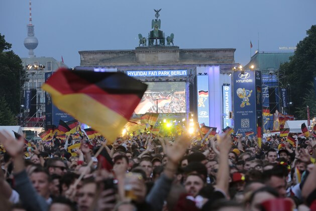 Thousands of German soccer fans wait for the live broadcast of the final match  between Germany and Argentina at the soccer World Cup in Rio de Janeiro, Brazil,  at a public viewing area called 'Fan Mile' in front of the Brandenburg Gate in Berlin, Sunday, July 13, 2014. (AP Photo/Markus Schreiber)