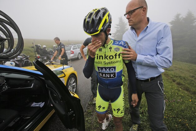 Spain's Alberto Contador abandons the race after crashing during the tenth stage of the Tour de France cycling race over 161.5 kilometers (100.4 miles) with start in Mulhouse and finish in La Planche des Belles Filles, France, Monday, July 14, 2014. At right is team manager Bjarne Riis of Denmark. (AP Photo/Christophe Ena)