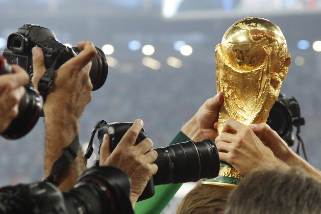 German players are surrounded by photographers during a victory lap after the World Cup final soccer match between Germany and Argentina at the Maracana Stadium in Rio de Janeiro, Brazil, Sunday, July 13, 2014. Germany won the match 1-0.  (AP Photo/Matthias Schrader)
