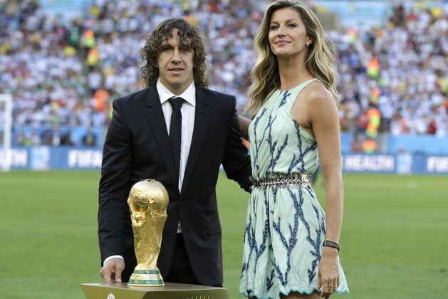 Former Spanish player Carles Puyol and model  Gisele Bundchen stand next to the World Cup trophy before the World Cup final soccer match between Germany and Argentina at the Maracana Stadium in Rio de Janeiro, Brazil, Sunday, July 13, 2014. (AP Photo/Natacha Pisarenko)