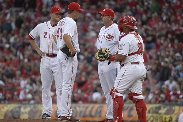 Cincinnati Reds manager Bryan Price (38) talks with relief pitcher Manny Parra (43) during a baseball game against the St. Louis Cardinals, Monday, March 31, 2014, on opening day in Cincinnati. (AP Photo/Michael Keating)