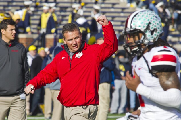 FILE - In this Nov. 30, 2013 file photo,  Ohio State head coach Urban Meyer responds to cheers from fans in Michigan Stadium as his team takes the field before an NCAA college football game against Michigan in Ann Arbor, Mich.  It seems as if No. 2 Ohio State has spent the past three months in a pressure-cooker. Now, after squeaking out its biggest win of the season against its bitter rival, the Buckeyes have to turn around and play yet another major showdown. They meet No. 10 Michigan State in the Big Ten championship game on Saturday. (AP Photo/Tony Ding, File)
