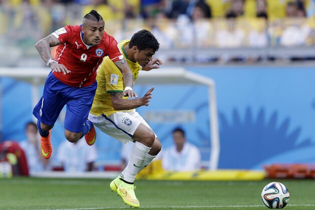Chile's Arturo Vidal, right, is challenged by Brazil's Thiago Silva during the World Cup round of 16 soccer match between Brazil and Chile at the Mineirao Stadium in Belo Horizonte, Brazil, Saturday, June 28, 2014. (AP Photo/Andre Penner)