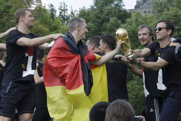 Bastian Schweinsteiger gives the trophy to team manager Oliver Bierhoff during a fan party after the arrival of the German national soccer team in Berlin Tuesday, July 15, 2014. Germany beat Argentina 1-0 on Sunday to win its fourth World Cup title. (AP Photo/Michael Sohn) Bastian Schweinsteiger gives the trophy to team manager Oliver Bierhoff during a fan party after the arrival of the German national soccer team in Berlin Tuesday, July 15, 2014. Germany beat Argentina 1-0 on Sunday to win its fourth World Cup title. (AP Photo/Michael Sohn)