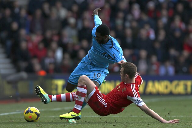 Tottenham Hotspur's Emmanuel Adebayor, left, is tackled by Southampton's Calum Chambers during their English Premier League soccer match at St Mary's stadium, Southampton, England, Sunday, Dec. 22, 2013. (AP Photo/Sang Tan)