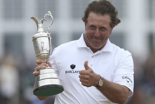 Phil Mickelson of the United States gestures as he holds up the Claret Jug trophy after winning the British Open Golf Championship at Muirfield, Scotland, Sunday July 21, 2013.  (AP Photo/Scott Heppell)