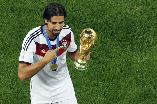 Germany's Sami Khedira points at the trophy after winning the World Cup final soccer match between Germany and Argentina at the Maracana Stadium in Rio de Janeiro, Brazil, Sunday, July 13, 2014. Mario Goetze volleyed in the winning goal in extra time to give Germany its fourth World Cup title with a 1-0 victory over Argentina on Sunday. (AP Photo/Fabrizio Bensch, Pool)