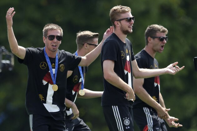Team captain Philipp Lahm celebrates with his teammate during a fan party after the arrival of the German national soccer team in Berlin Tuesday, July 15, 2014. Germany beat Argentina 1-0 on Sunday to win its fourth World Cup title.  (AP Photo/Petr David Josek)