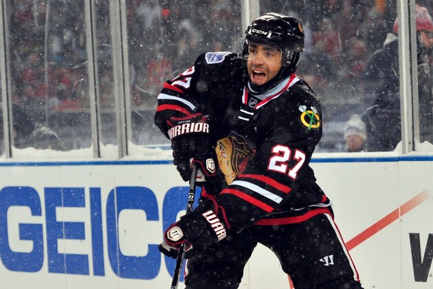 Mar 1, 2014; Chicago, IL, USA; Chicago Blackhawks defenseman Johnny Oduya passes the puck against the Pittsburgh Penguins during the second period in a Stadium Series hockey game at Soldier Field. Mandatory Credit: Rob Grabowski-USA TODAY Sports