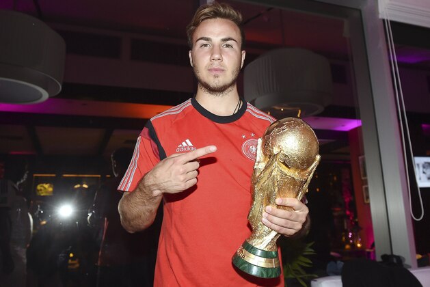 Photo provided by Germany soccer federation DFB shows Germany's Mario Goetze with the trophy during the party of the German soccer federation after Germany beat Argentina 1-0 after extra-time in the soccer World Cup final to win its fourth title in Rio de Janeiro, Brazil, Sunday, July 13, 2014. (AP Photo/DFB, Markus Gilliar, pool)