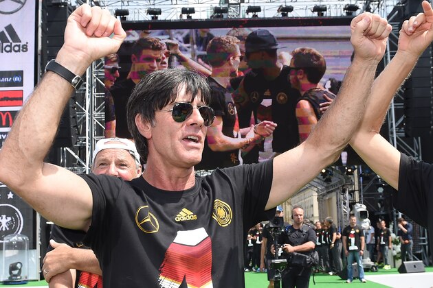 German national soccer coach Joachim Loew celebrates on stage at the German team victory ceremony , near the Brandenburg Gate in Berlin,  Tuesday July 15,  2014.  Germany's World Cup winners shared their fourth title with hundreds of thousands of fans by parading the trophy through cheering throngs to celebrate at the Brandenburg Gate on Tuesday. An estimated 400,000 people packed the