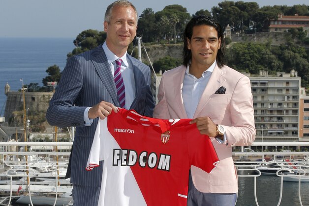 Soccer player Radamel Falcao of Colombia, right, holding up his new shirt during his official presentation after signing for AS Monaco,poses with sports director of AS Monaco Vadim Vasilyed, Tuesday, July 9, 2013, in Monaco. (AP Photo/Lionel Cironneau)