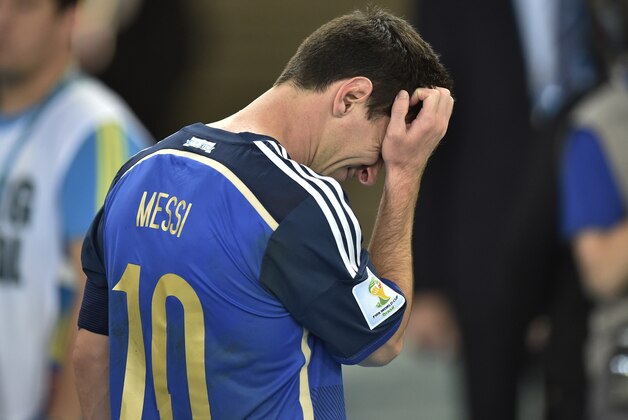 Argentina's Lionel Messi scratches his head as he goes up to get his runners-up medal after the World Cup final soccer match between Germany and Argentina at the Maracana Stadium in Rio de Janeiro, Brazil, Sunday, July 13, 2014. Germany won the match 1-0  (AP Photo/Martin Meissner)