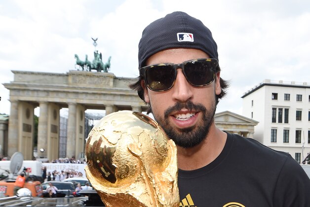 BERLIN, GERMANY - JULY 15: Sami Khedira celebrates on the open top bus at the German team victory ceremony on July 15, 2014 in Berlin, Germany. Germany won the 2014 FIFA World Cup Brazil match against Argentina in Rio de Janeiro on July 13.  (Photo by Markus Gilliar - Pool/Getty Images)