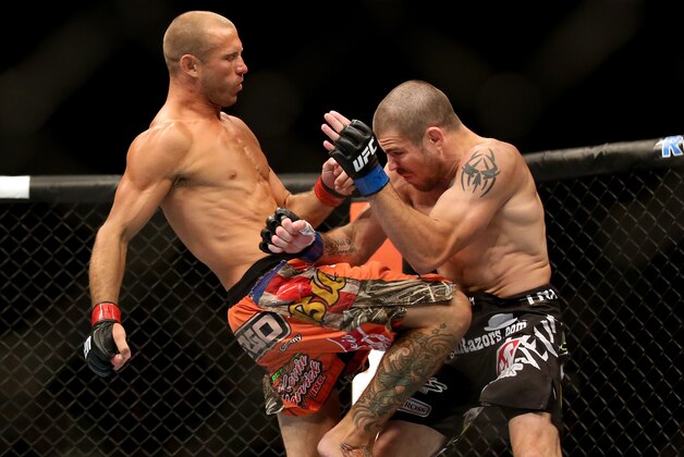 Jul 16, 2014; Atlantic City, NJ, USA; Donald Cerrone (red gloves) throws a knee at Jim Miller (blue gloves) during a 5-round lightweight bout at Revel Casino. Mandatory Credit: Bill Streicher-USA TODAY Sports