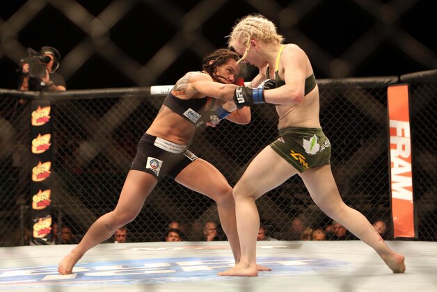 Jul 16, 2014; Atlantic City, NJ, USA;  Claudia Gadelha (red gloves) exchanges punches with Tina Lahdemaki (blue gloves) during a 115-pound women's division bout at Revel Casino. Mandatory Credit: Bill Streicher-USA TODAY Sports