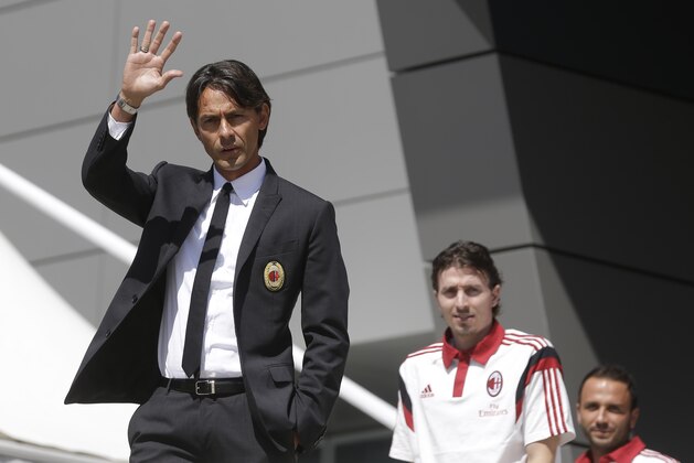 AC Milan coach Filippo Inzaghi waves during the presentation of the upcoming 2014-15 season at the AC Milan headquarter in Milan, Italy, Thursday, July 10, 2014. In background are midfielder Riccardo Montolivo  and forward Giampaolo Pazzini. (AP Photo/Luca Bruno)
