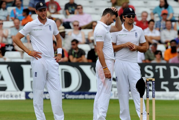 England's Stuart Broad, left, James Anderson and Alastair Cook, right, confer during day five of the first Test between England and India at Trent Bridge cricket ground, Nottingham, England, Sunday, July 13, 2014. (AP Photo/Rui Vieira)