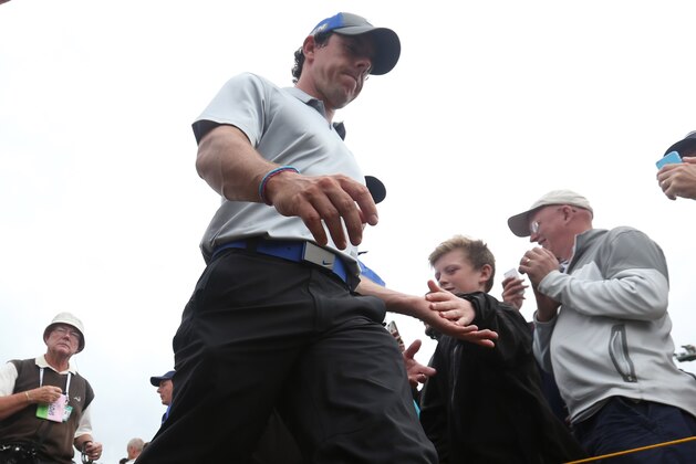 Rory McIlroy of Northern Ireland shakes hands with a young fan as he walks to the 18th tee box during the third day of the British Open Golf championship at the Royal Liverpool golf club, Hoylake, England, Saturday July 19, 2014. (AP Photo/Jon Super)