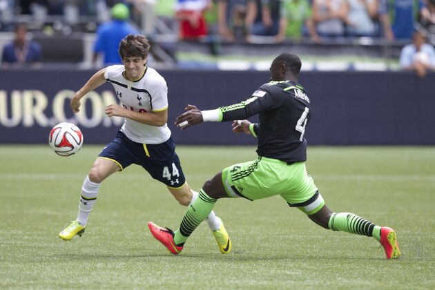 Tottenham Hotspurs Cristian Ceballos,left, tries to get around Seattle Sounders' Jalil Anibaba during the second half of a friendly soccer match in Seattle, Saturday, July 19, 2014. The match ended in a 3-3 draw. (AP Photo/Stephen Brashear)