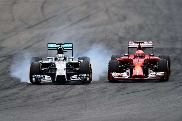 HOCKENHEIM, GERMANY - JULY 20:  Lewis Hamilton of Great Britain and Mercedes GP locks up as he passes Kimi Raikkonen of Finland and Ferrari during the German Grand Prix at Hockenheimring on July 20, 2014 in Hockenheim, Germany.  (Photo by Christopher Lee/Getty Images)
