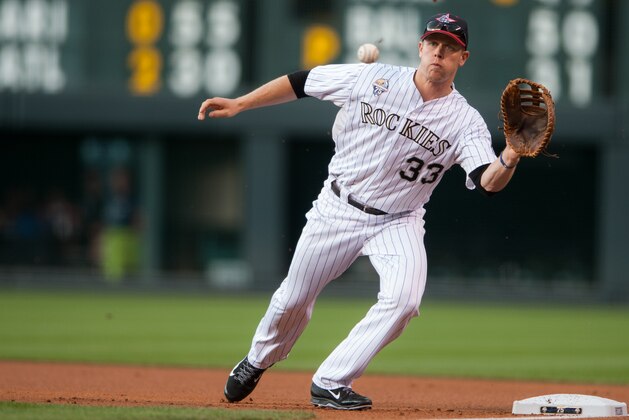 DENVER, CO - JULY 4:  Justin Morneau #33 of the Colorado Rockies reaches to field a putout attempt in the first inning of a game against the Los Angeles Dodgers at Coors Field on July 4, 2014 in Denver, Colorado. (Photo by Dustin Bradford/Getty Images)