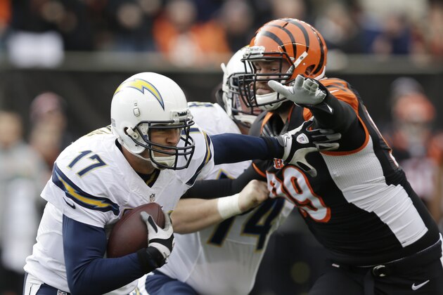 Philip rivers, de los Chargers de San Diego, acarrea el balón y trata de eludir a Margus Hunt, defensive end de los Bengals de Cincinnati, durante el duelo de comodines de la Conferencia Americana, disputado el domingo 5 de enero de 2014 (AP Foto/Al Behrman) Philip rivers, de los Chargers de San Diego, acarrea el balón y trata de eludir a Margus Hunt, defensive end de los Bengals de Cincinnati, durante el duelo de comodines de la Conferencia Americana, disputado el domingo 5 de enero de 2014 (AP Foto/Al Behrman)