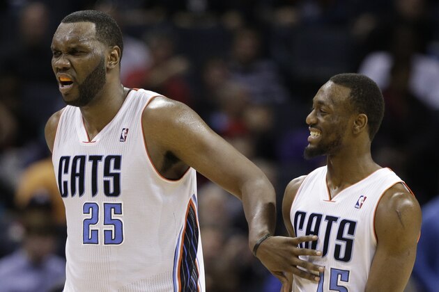 Charlotte Bobcats' Al Jefferson (25) and Kemba Walker (15) react during the second half of an NBA basketball game against the Chicago Bulls in Charlotte, N.C., Wednesday, April 16, 2014. The Bobcats won 91-86 in overtime. (AP Photo/Chuck Burton)