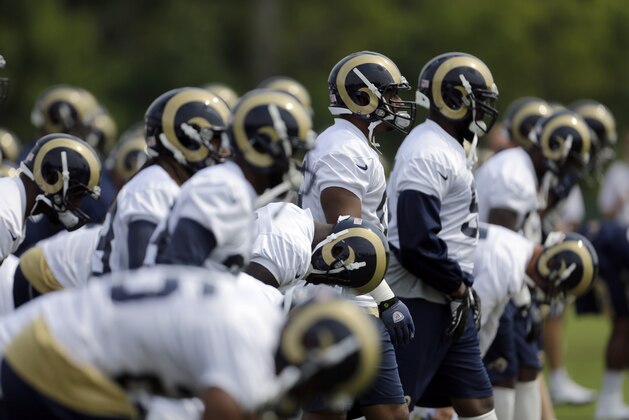 Members of the St. Louis Rams warm up during training camp at the NFL football team's practice facility Friday, Aug. 16, 2013, in St. Louis. (AP Photo/Jeff Roberson)