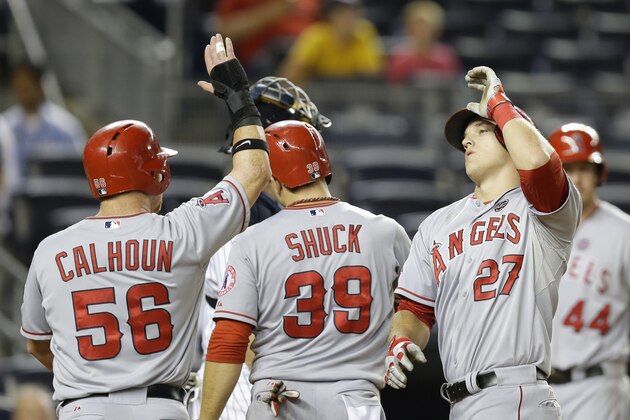 Los Angeles Angels Mike Trout, right, celebrates with Los Angeles Angels Kole Calhoun (56), Los Angeles Angels J.B. Shuck (39) who scored on Trout's ninth-inning, three-run, home run off New York Yankees relief pitcher Dellin Betances (61) in the Angels 14-7 loss to the Yankees in a baseball game Tuesday, Aug. 13, 2013, in New York. (AP Photo/Kathy Willens)