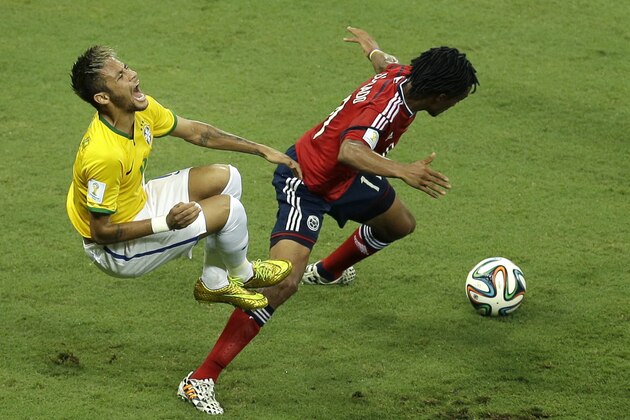 Brazil's Neymar, left, falls after challenging Colombia's Juan Cuadrado during the World Cup quarterfinal soccer match between Brazil and Colombia at the Arena Castelao in Fortaleza, Brazil, Friday, July 4, 2014. (AP Photo/Themba Hadebe)